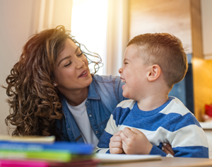 Stock photo of caregiver assisting child with autism