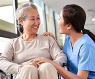 Asian elder with caregiver in facility