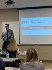 Photo of Dave Skovholt, outreach coordinator for DLI's Labor Standards Division, presenting information about the state's wage theft law.