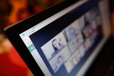 A close up of a computer screen with participants in a videoconference meeting.