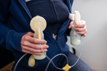 Person using electronic breast pump