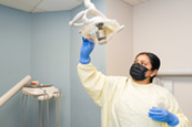 Dental apprentice adjusting room lighting