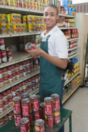 Portrait of a smiling male teenage supermarket employee at work 