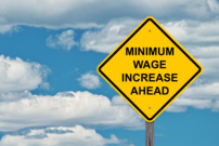 Stop sign with text, "Minimum wage increase ahead"