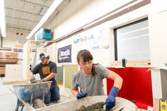 Two construction workers laying tile