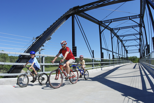 family biking on manning bridge