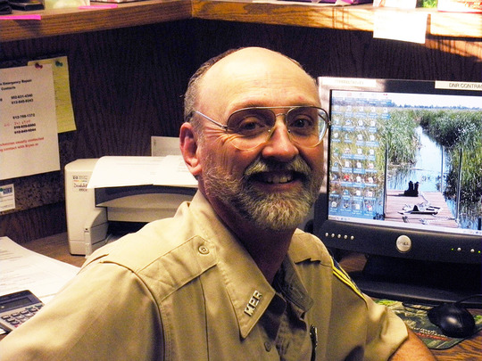 Daryl Gross smiling in his office at work