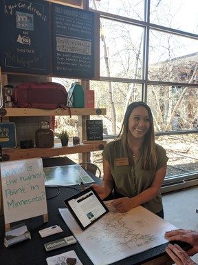 Woman sitting at adventure station kiosk