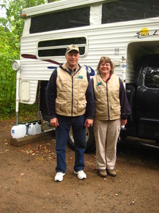 man and woman standing next to their recreational vehicle
