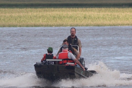 conservation officers use a boat to rescue civilians during flooding