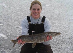 angler with a northern pike on the ice