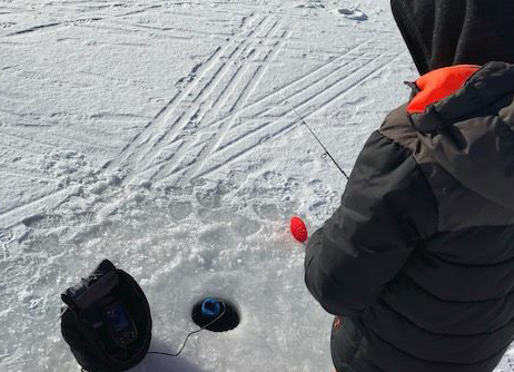 kid at an ice fishing hole