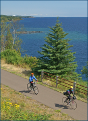 Two people bicycling next to Lake Superior on the Gitchi-Gami State Trail