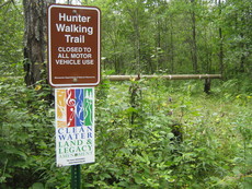 Hunter Walking Trail sign along with Legacy Amendment sign