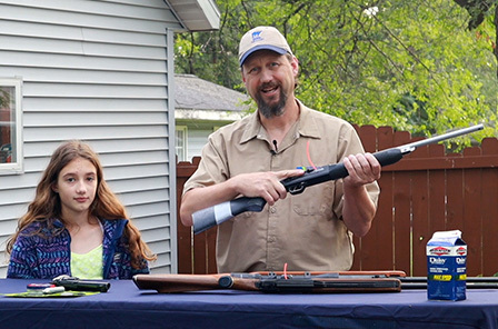 Benji Kohn holding air rifle with daughter
