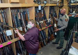 DNR conservation officer and enforcement staff doing inventory of confiscated firearms and bows