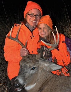 woman and daughter holding a nice buck harvested
