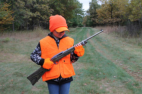 hunter in orange employing a two-handed firearms carry