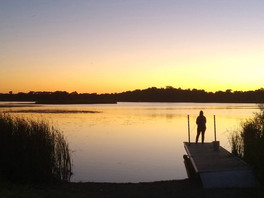 scene from Lake Maria State Park of angler fishing at dusk from a dock