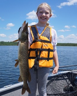 girl holding a northern pike on a boat