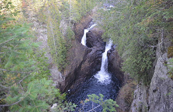 Two waterfalls seen from up high, surrounded by trees