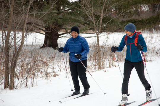 Two women of color cross country skiing.