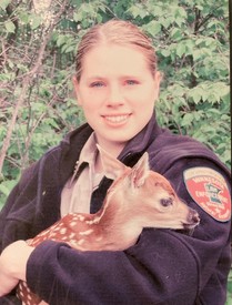 Woman in uniform holding baby deer