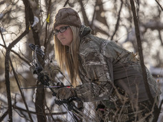 archery hunter in the snowy woods