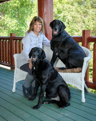 Kat Norby with two black lab dogs