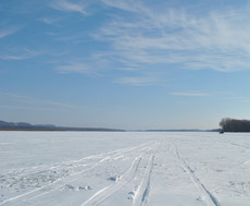 scene on ice with tracks from a vehicle that had driven on a lake