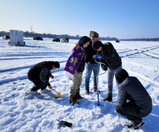 kids ice fishing on a lake in 2018
