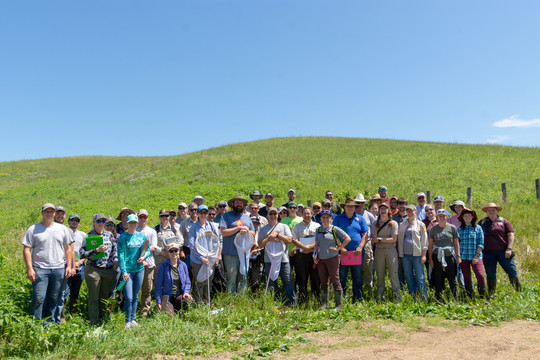 Land managers, biologists, and other conservation professionals standing in front of a remnant prairie