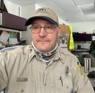 Man  in DNR uniform taking a selfie at the office.