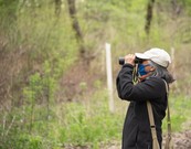 Woman with binoculars in forest