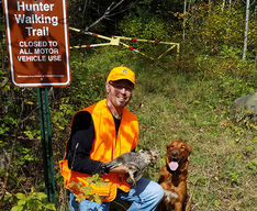 hunter walking trail sign and hunter with dog and harvested grouse