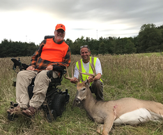 hunter in a wheelchair and DNR wildlife staff with a deer hunter harvested