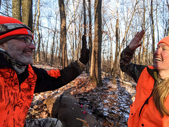 two hunters, father and daughter, high fiving after she got her archery buck