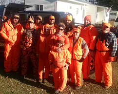 11 people in a group shot where they're all wearing their blaze orange