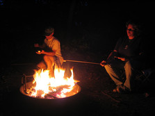 campfire with two people around fire ring at night