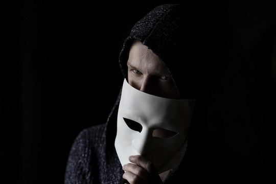 A person hiding behind a mask
