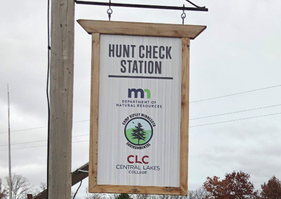 sign over deer check station at Camp Ripley with DNR, Camp Ripley and CLC logos