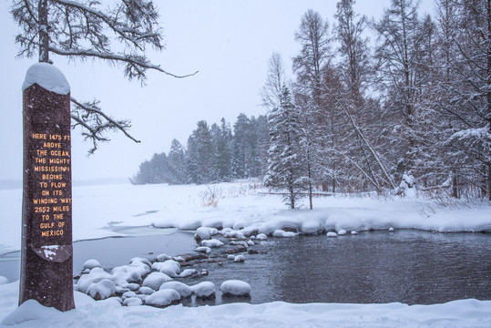 Iconic Mississippi Headwaters monument with Lake Itasca in the background, in winter.