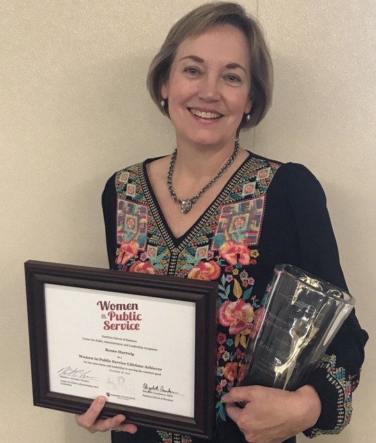 Renee Hartwig holding her award