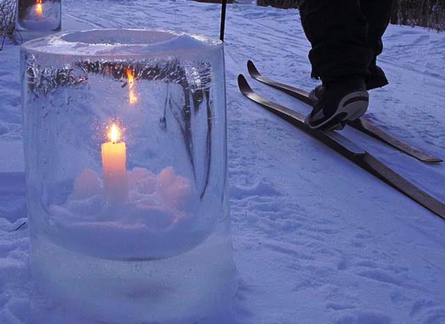 Candle glowing in ice globe on trail
