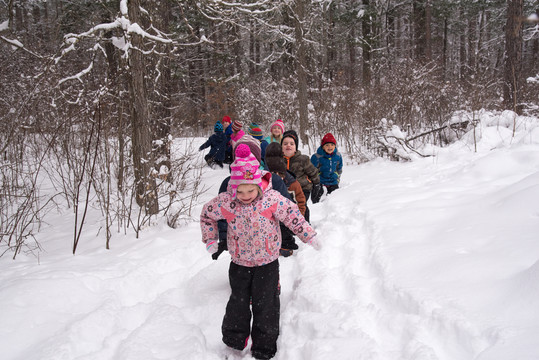A group of preschoolers trek through the snow at Itasca State Park