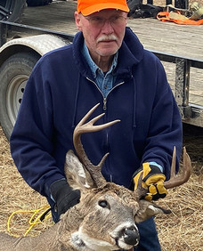 hunter with orange cap holding buck he harvested