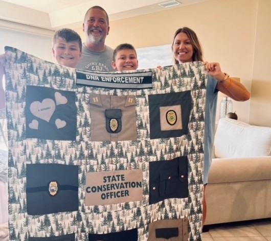 A family holding a quilt