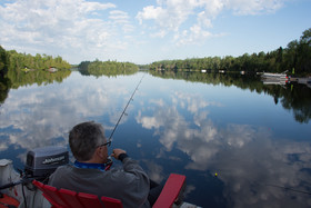 Man fishing from chair on a dock