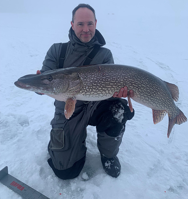 angler with record tie of northern pike on Mille Lacs Lake during the winter