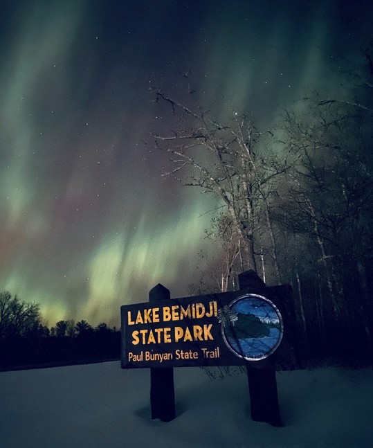 Northern Lights over the entrance sign for Lake Bemidji State Park.